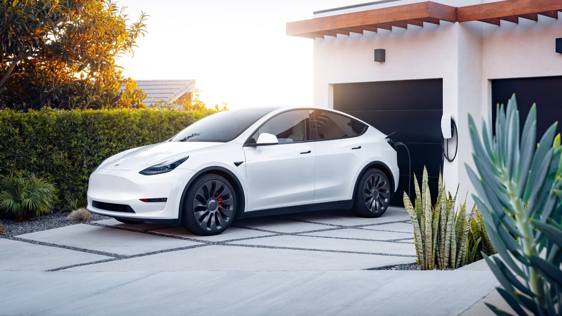 Nabíjení elektromobilu Tesla Model Y přes wallbox před garáží