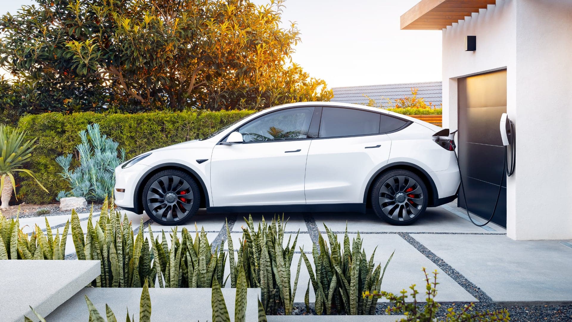 Nabíjení elektromobilu Tesla Model Y přes wallbox před garáží